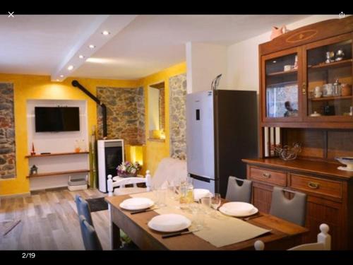 ein Esszimmer mit einem Tisch und einem Kühlschrank in der Unterkunft casamariu in Lucca