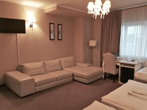 a living room with a couch and a table at Riviera Resort Airport Modlin in Olszewnica Nowa