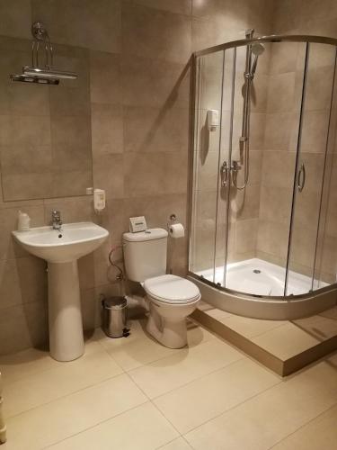 a bathroom with a shower and a toilet and a sink at Riviera Resort Airport Modlin in Olszewnica Nowa