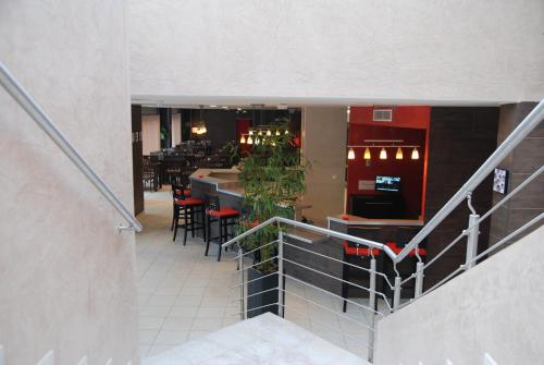 a staircase leading to a restaurant with a bar at HOTEL RESTAURANT PARIS PACIFIC PARIS-VILLEJUIF- PRES DU METRO L'HAY LES ROSES LIGNE 14 - Direct PARIS-AEROPORT ORLY ET INSTITUT GUSTAVE ROUSSI in Villejuif