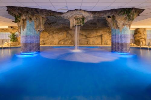 a swimming pool with blue water in a building at htop Royal Star SPA - Fun in Lloret de Mar