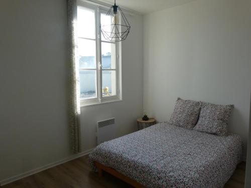 a bedroom with a bed and a window at Appartement les Elfes in Capbreton