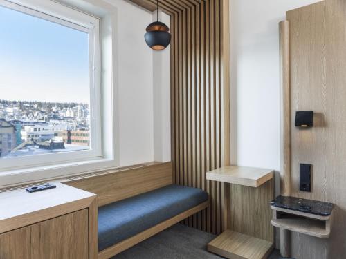 a room with a window and a blue bench at Radisson Blu Hotel Tromsø in Tromsø