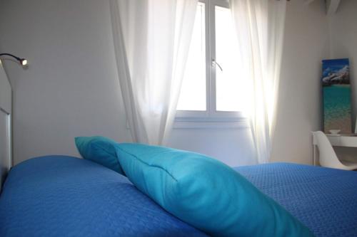 a blue bed with a blue pillow in a bedroom at R House Budoni in Budoni