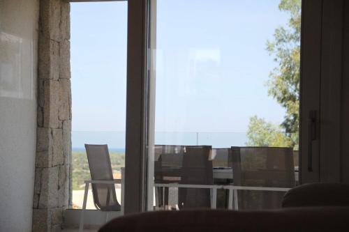a room with a window with a table and chairs at R House Budoni in Budoni