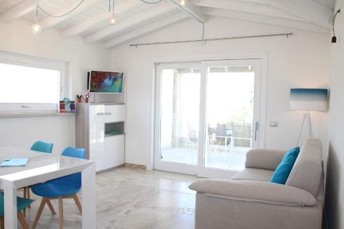 a white living room with a table and a couch at R House Budoni in Budoni
