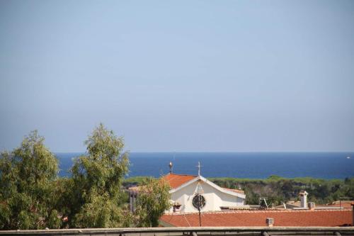a white church with the ocean in the background at R House Budoni in Budoni