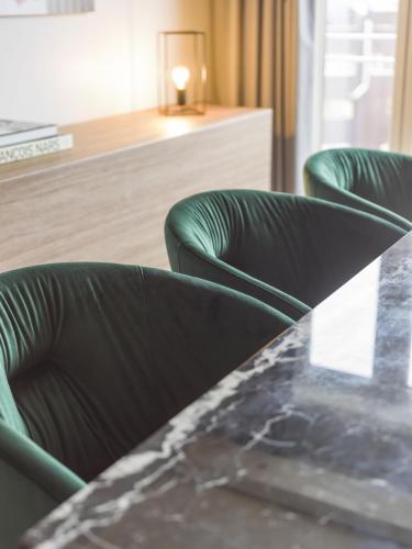 two green chairs and a table in a room at Radisson Blu Hotel Tromsø in Tromsø
