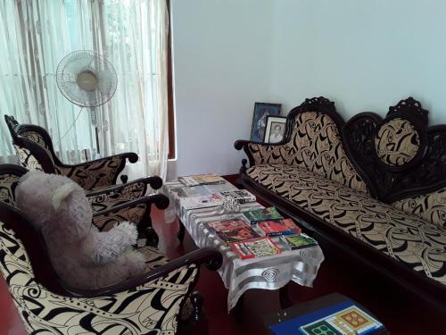 a living room with a couch and a table and chairs at Green Villa in Hikkaduwa