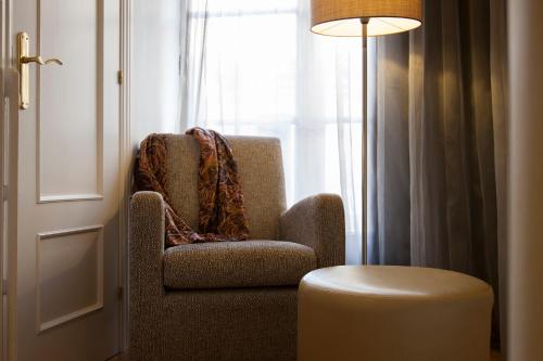 a chair sitting next to a window with a lamp at Hostal Goya in Barcelona