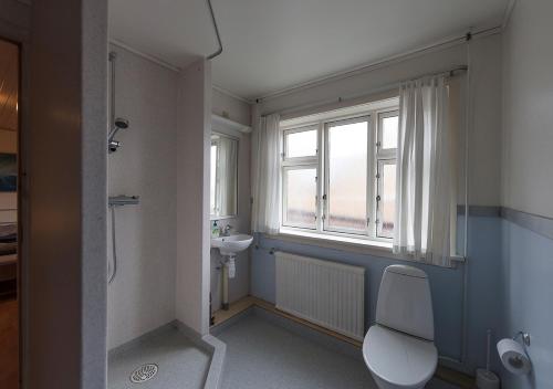 łazienka z toaletą, umywalką i oknem w obiekcie 62N Guesthouse - City Center w mieście Torshavn