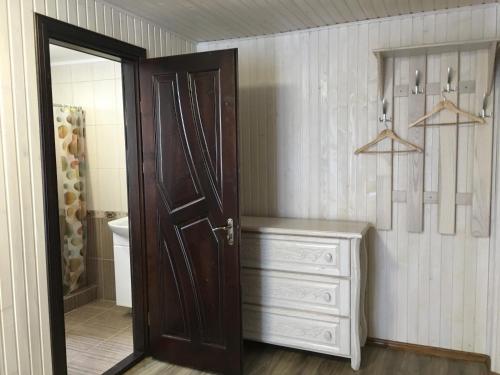 a bathroom with a wooden door and a dresser at VULYK z MEDOM in Bukovel