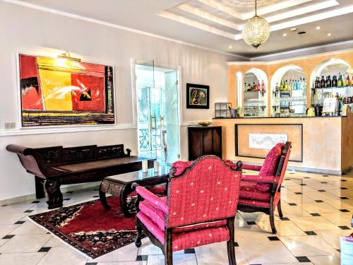 a living room with a piano and two chairs at Arts Club Suite & Spa in Chianciano Terme