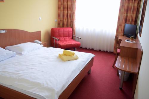 um quarto com uma cama com uma toalha amarela em Penzion Letališče em Murska Sobota