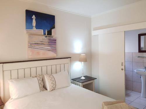 1 dormitorio con cama blanca y lavamanos en Point Village Accommodation - Portobello 26 en Mossel Bay