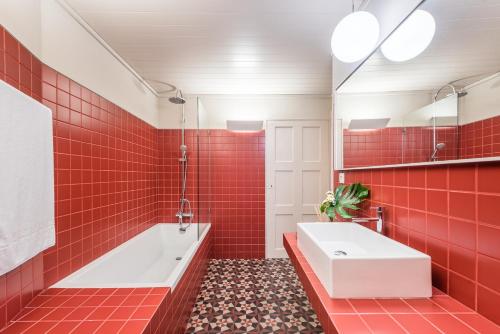 ギマランイスにあるCasa da Cera da Porta da Vilaの赤いタイル張りのバスルーム(バスタブ、シンク付)