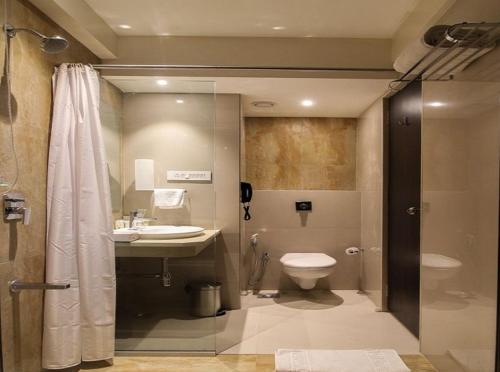 a bathroom with a toilet and a sink and a shower at KRC Annexe Tezpur in Tezpur
