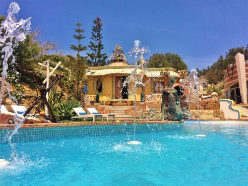a swimming pool with a fountain in front of a house at Villa Ana Margarida Beach in Ericeira