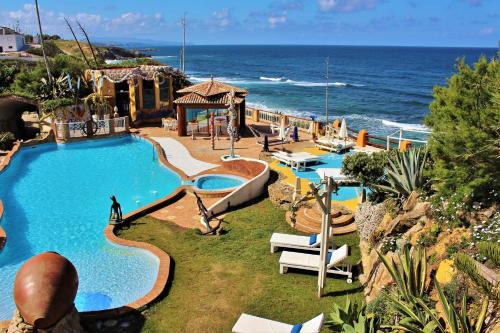 a resort with a swimming pool next to the ocean at Villa Ana Margarida Beach in Ericeira