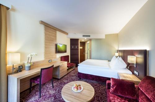 ein Hotelzimmer mit einem Bett und einem Tisch in der Unterkunft EurothermenResort Bad Ischl - Hotel Royal 4-Sterne Superior in Bad Ischl