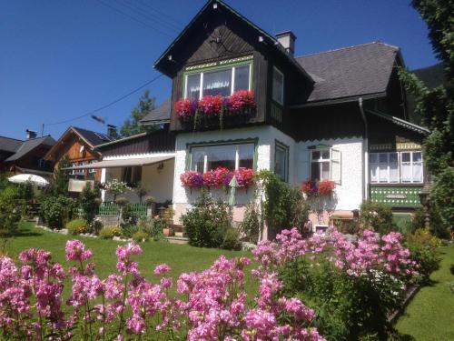 una casa con flores en el patio delantero en Ferienwohnung Sonnschein, en Bad Mitterndorf