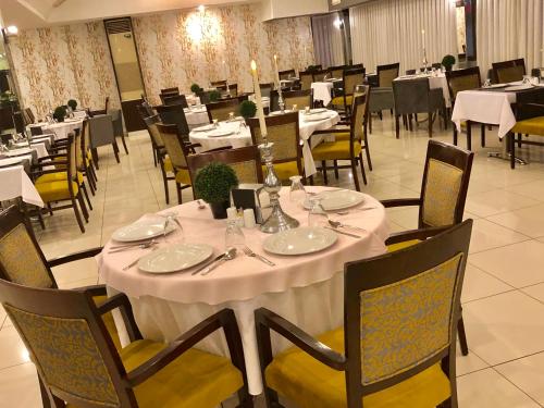 a dining room with a white table and chairs at Laodikya Hotel in Denizli