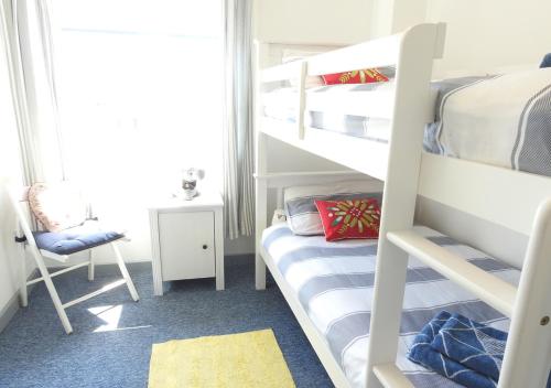 - une chambre avec 2 lits superposés et une chaise dans l'établissement Harbour View 4, à Gosport