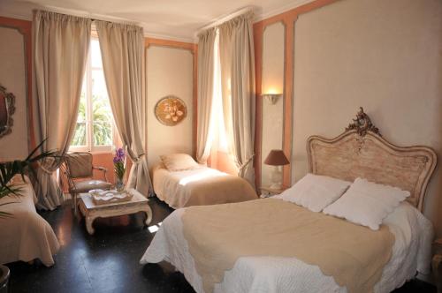 a hotel room with two beds and a window at Villa Valflor chambres d'hôtes et appartements in Marseille