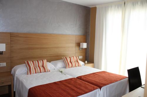 a bedroom with a large bed with a wooden headboard at Hotel Carmen in La Cala de Mijas