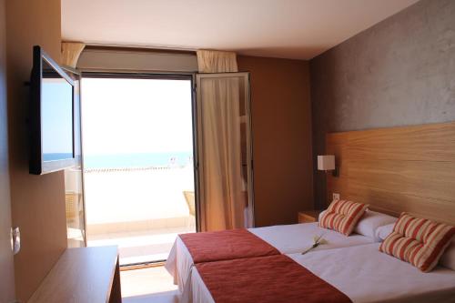 a bedroom with a bed and a large window at Hotel Carmen in La Cala de Mijas