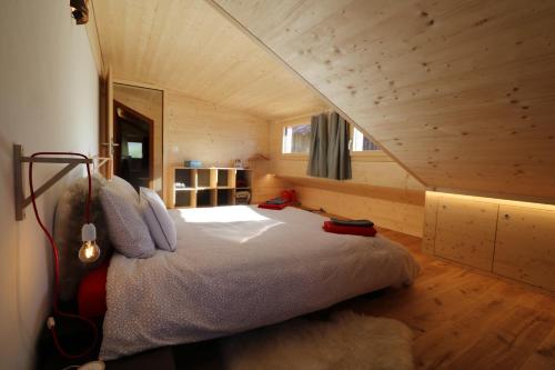 a bedroom with a large bed in a log cabin at Chalet Rouge Coeur in Fenalet Sur Bex
