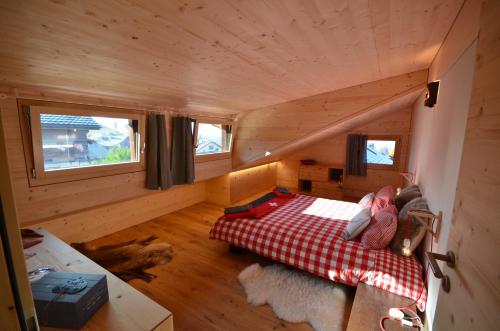 a small room with a bed in a log cabin at Chalet Rouge Coeur in Fenalet Sur Bex