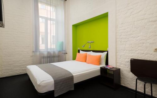 a bedroom with a large bed with a green headboard at Station Hotel S13 in Saint Petersburg