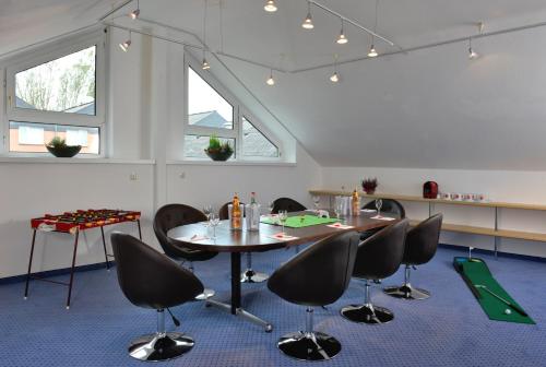 a room with a table and chairs and windows at Michel Hotel Hodenhagen in Hodenhagen