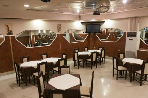 a dining room with tables and chairs and a wall with mirrors at Hotel Fantasy in Lyubimets