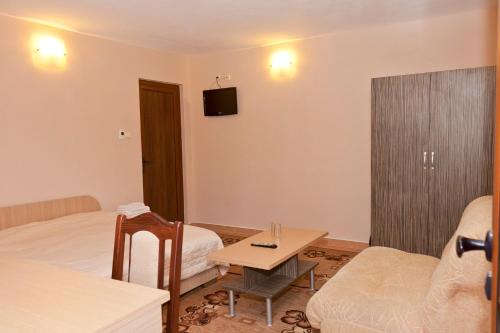 a hotel room with a bed and a table and a couch at Hotel Fantasy in Lyubimets