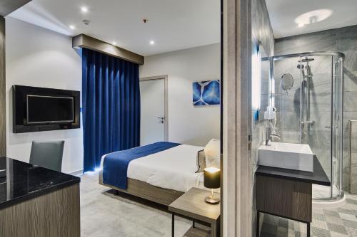 a hotel room with a bed and a shower at The District Hotel in St Julian's