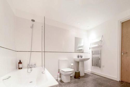 a white bathroom with a toilet and a sink at Modern 2 Bedroom Apartment in City Centre with Balcony in Manchester
