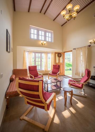 a living room with chairs and a table at The Realm in Coonoor