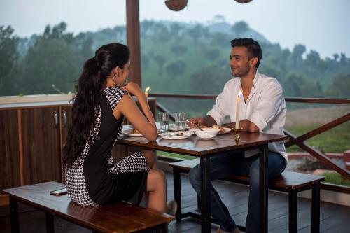a man and a woman sitting at a table at The Realm in Coonoor