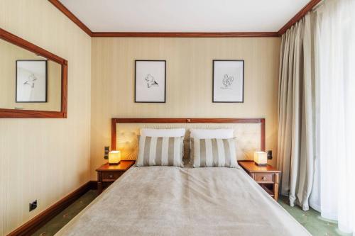 a bedroom with a bed with two lamps on two tables at Prestige Apartment with Sauna by Grand Apartments in Sopot