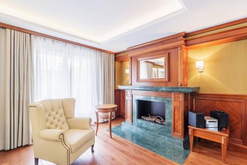 a living room with a fireplace and a chair at Prestige Apartment with Sauna by Grand Apartments in Sopot