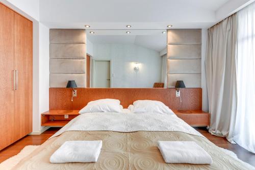 グダニスクにあるMilano Premium - Neptun Parkのベッドルーム1室(大型ベッド1台、タオル2枚付)