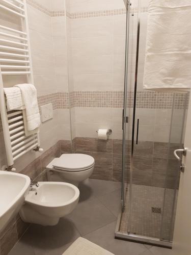 a bathroom with a toilet and a glass shower at Hotel De La Plage in Rimini