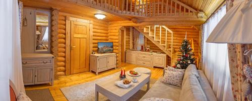 a living room in a log cabin with a christmas tree at Hotel Yastrebets Wellness & Spa in Borovets