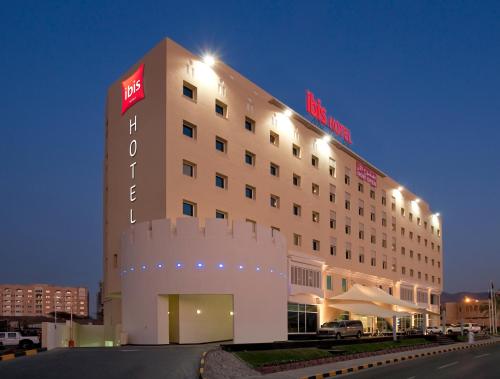 a large building with a large clock on the side of it at ibis Muscat in Muscat