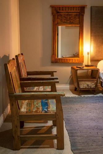a room with two wooden chairs and a mirror at Middelwater Farm Hotel in Bloemfontein