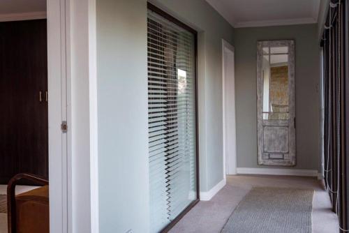a hallway with a window with blinds at Middelwater Farm Hotel in Bloemfontein
