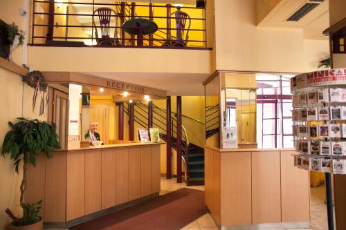 a man sitting at a counter in a building at City Hotel Pilvax in Budapest