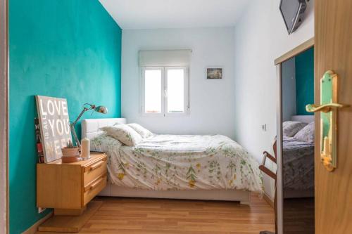 mała sypialnia z łóżkiem i oknem w obiekcie Apartamento Urgel w Madrycie